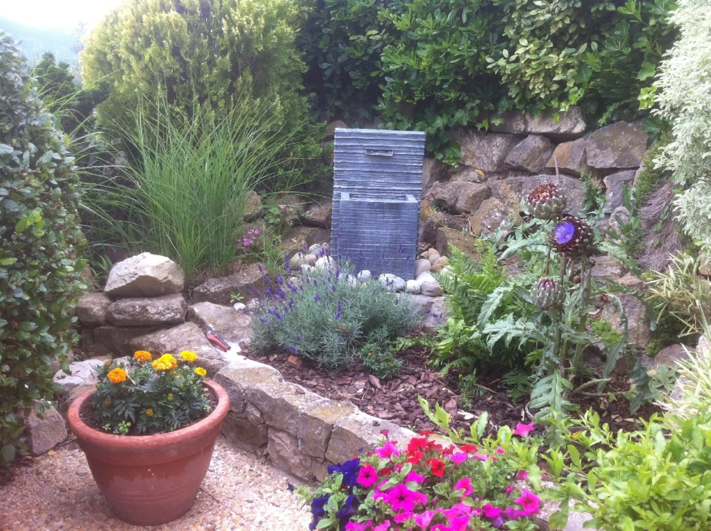 personne plantant un réservoir d'eau en terre cuite dans une plantation de jardin